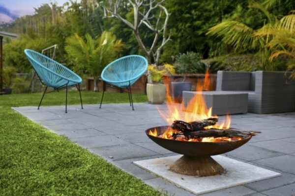 A firepit area with bluestone pavers and outdoor seats.