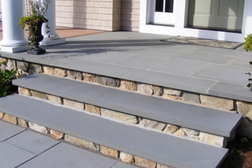 Bluestone coping tiles that have been used as step treads.